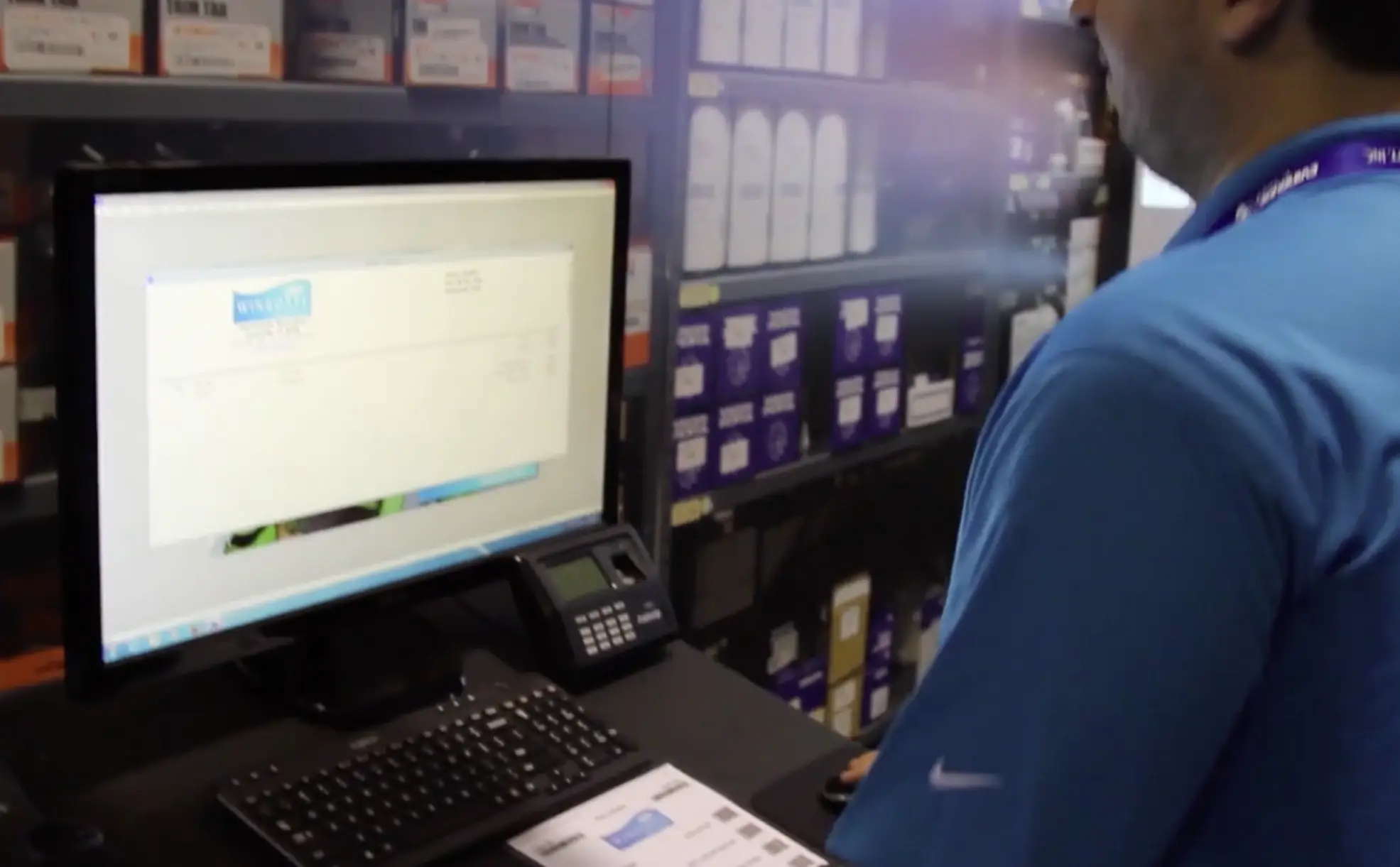 Person using winboats software on a desktop computer in a parts storage area, representing the dealership operations video library.